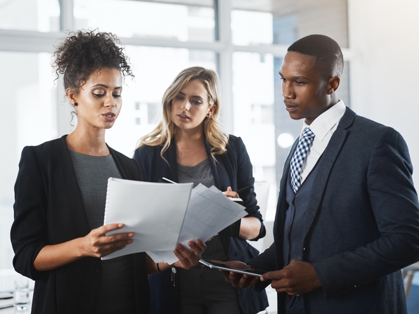 three attorneys look at paper files